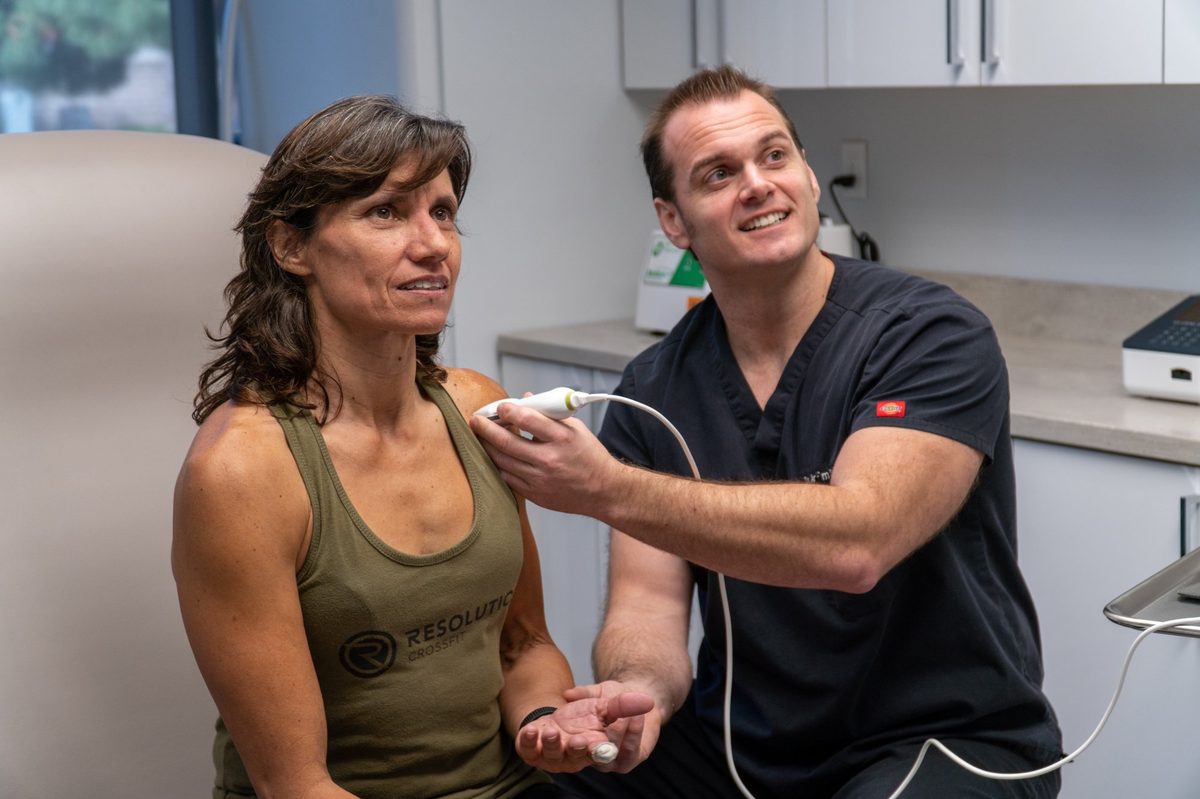 Dr. Schulte performing ultrasound-guided sports medicine evaluation on a CrossFit athlete